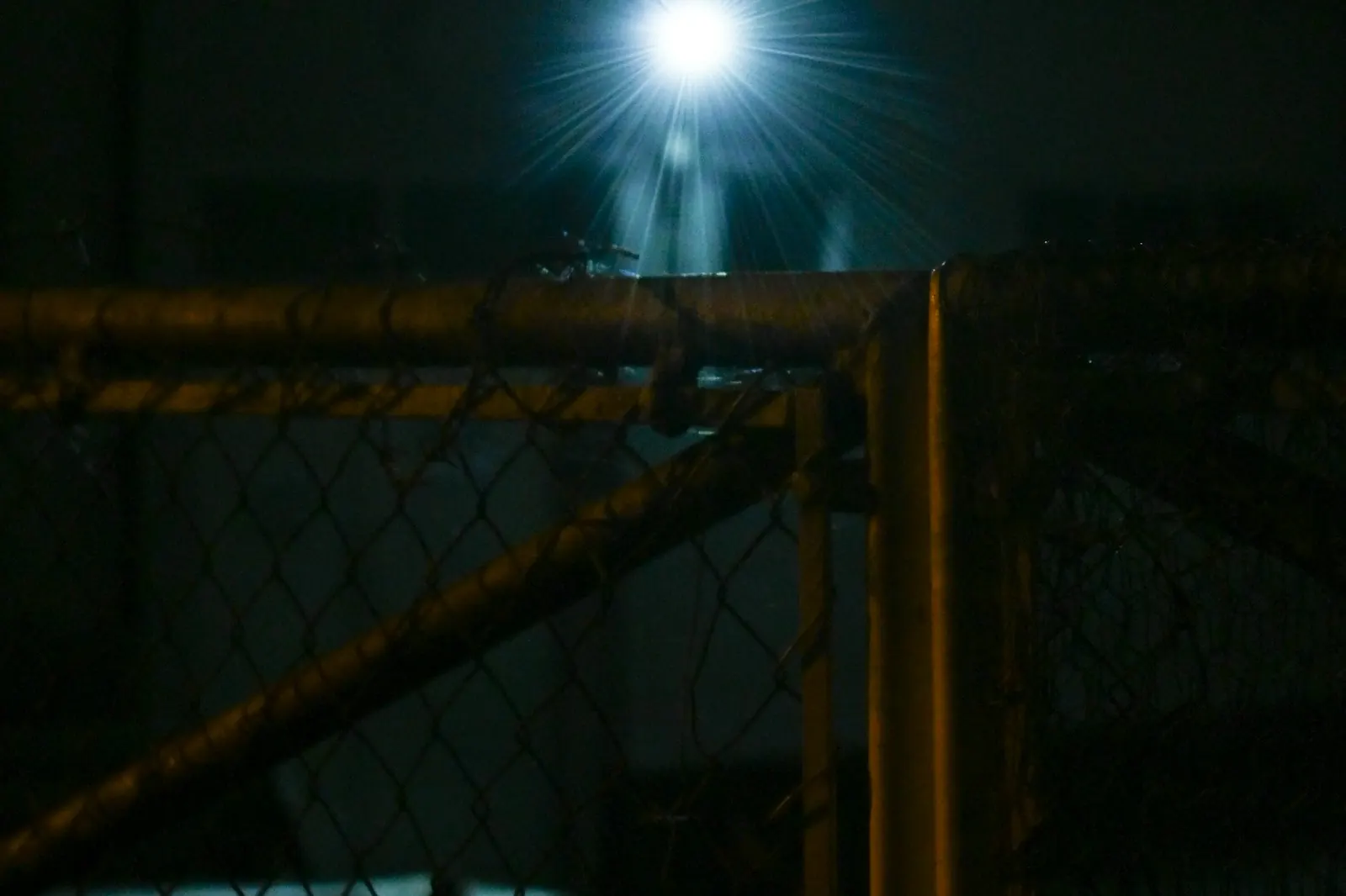 Clôture de site éclairée par un projecteur la nuit